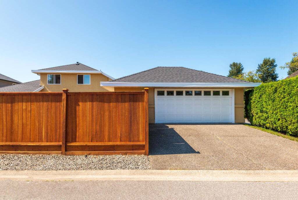 large brown privacy fence in front of suburban home